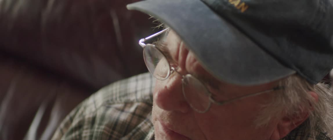Portrait of an elderly man sitting thoughtfully and taking off his glasses