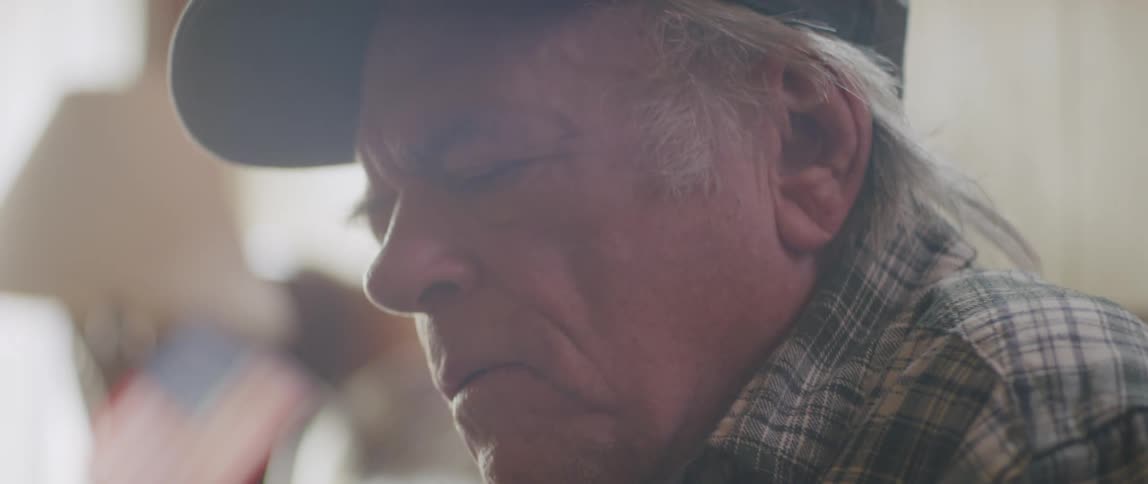 Side portrait of an elderly man reading and taking off his glasses and having a facial expression of revolt