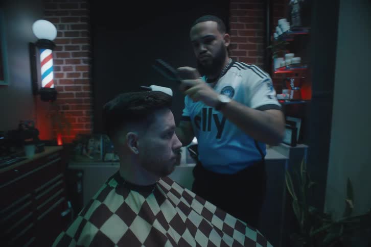 A barber is cutting the hair of a customer