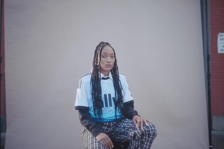 A black woman sitting on a stool outside
