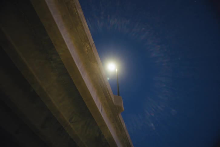 Bridge of a viaduct through the city with lampposts at night