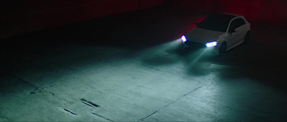 Parked car turning on its headlights at night
