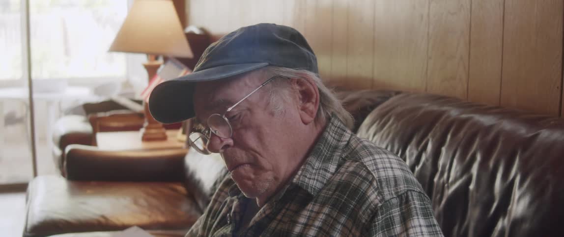 A man sits up and thinks after reading something in a booklet