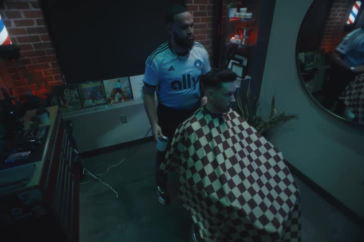 Barber using a hairdryer and comb on his clients hair