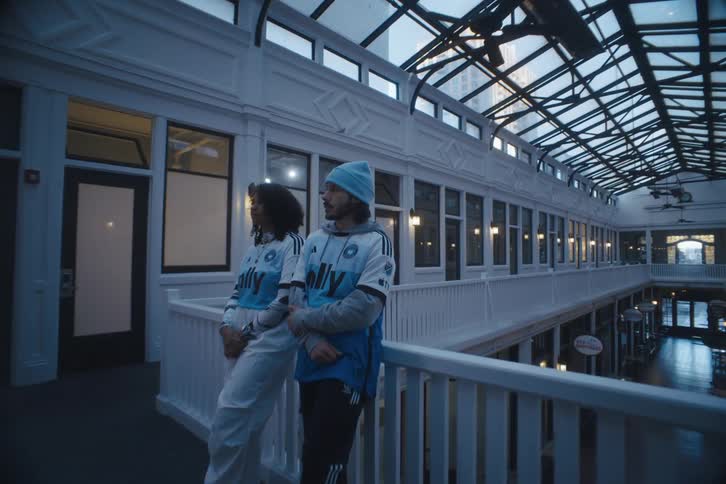 A man and a woman leaning against a guard rail in a mall