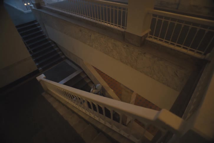 Two people running down the stairs of a building