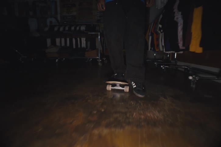 Someone skateboarding across a closed clothing store