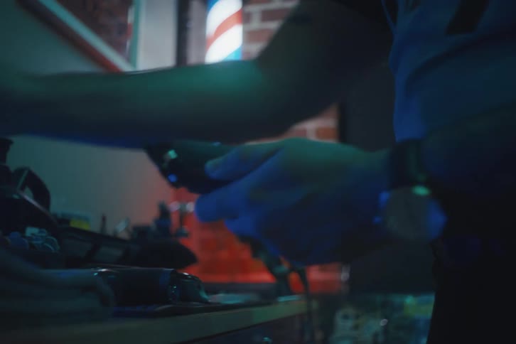 Hands of a person who is cleaning a shaver and placing it on a table