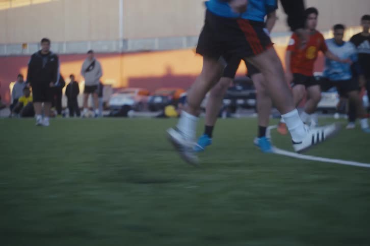 During a training game a soccer player leads the ball past the other players and shoots it towards the goal