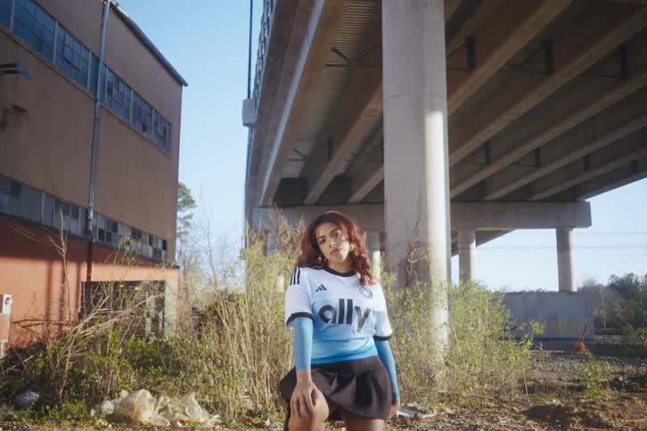 A woman is standing under the overpass