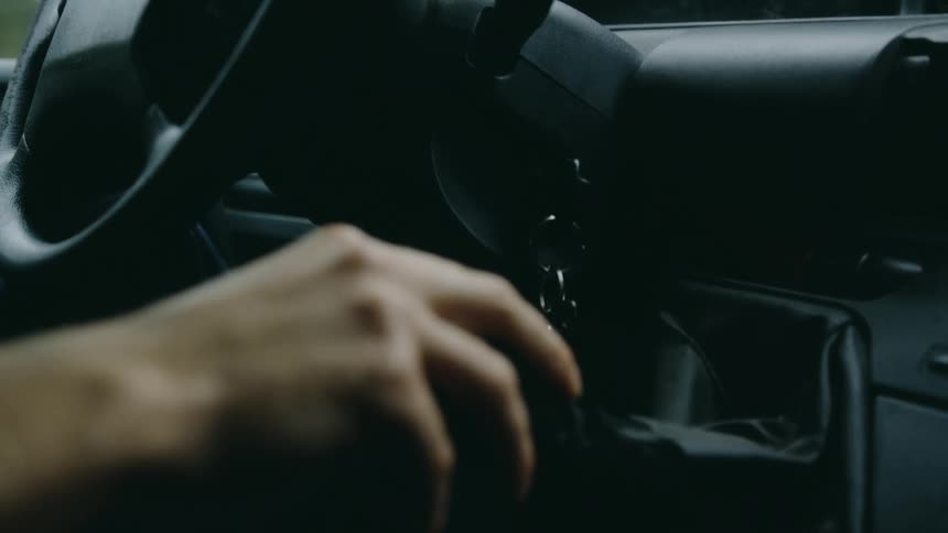 A hand of a person who is driving the car and his hand is changing gear