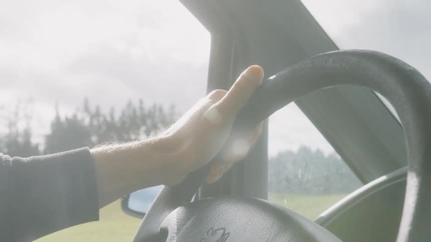A person is driving a car during the day