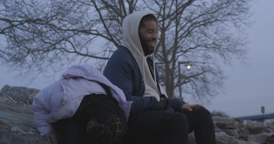 Father and daughter sitting outdoors laughing