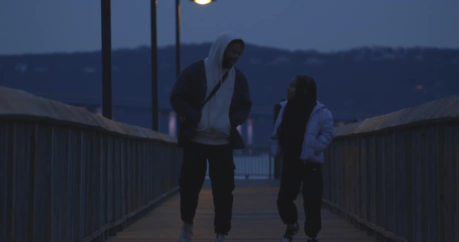 Father and daughter dancing on a bridge at night