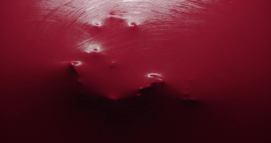 Round objects looking like fingers passing over a red surface on the other side