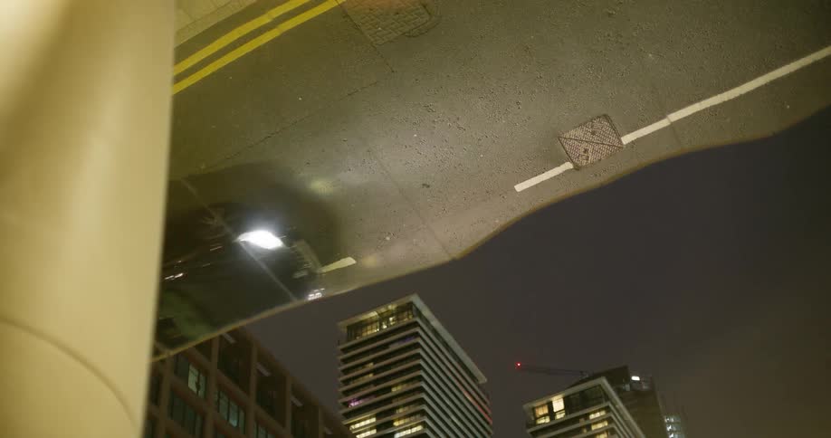 Cars reflected in the roof of a glass building