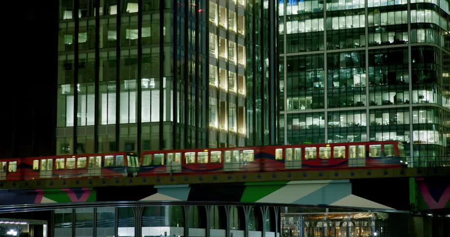A train crosses a city bridge with high-rises in the background