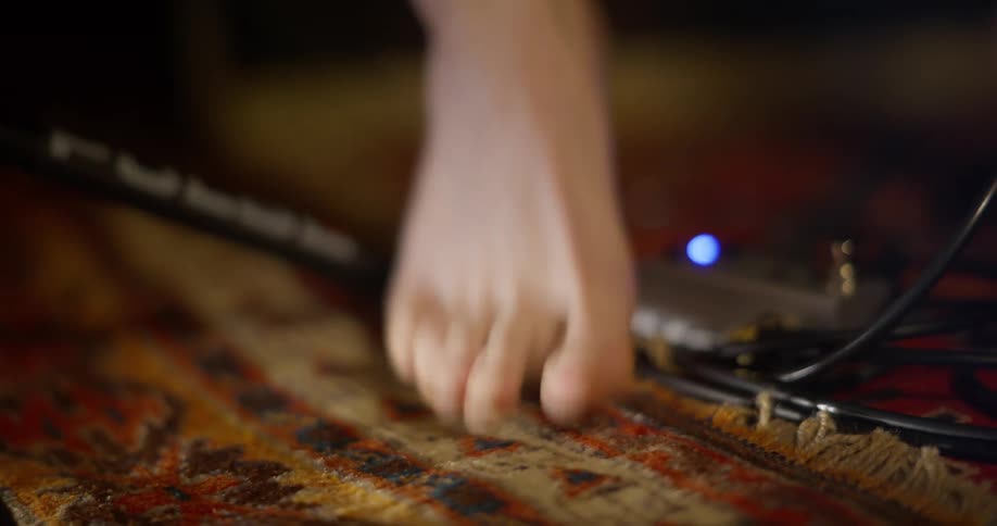A bare foot tapping a beat on an ornate carpet
