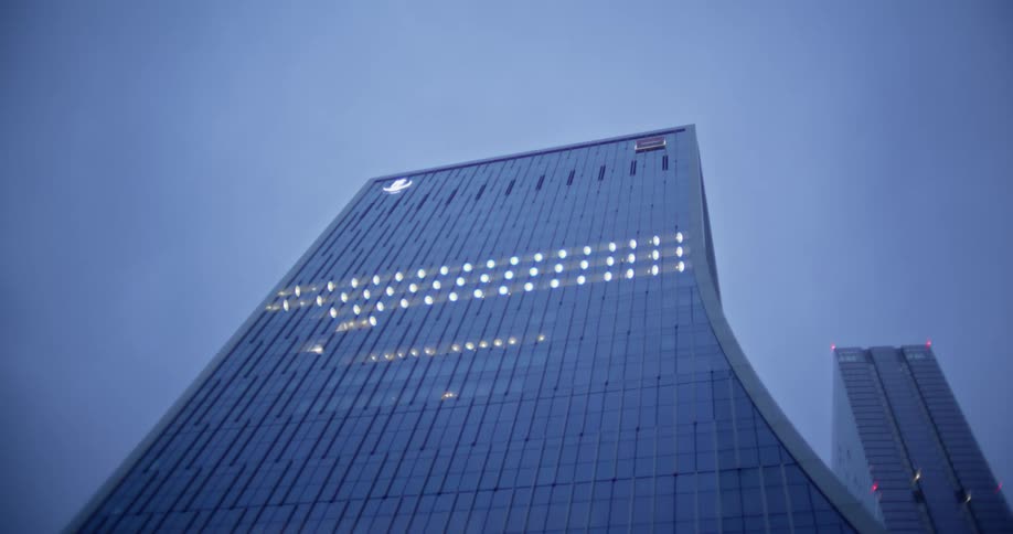 Commercial plane flying over skyscrapers in a metropolis on a cloudy day