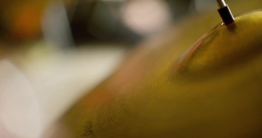 Extreme close up of a drum symbol being hit with a drumstick
