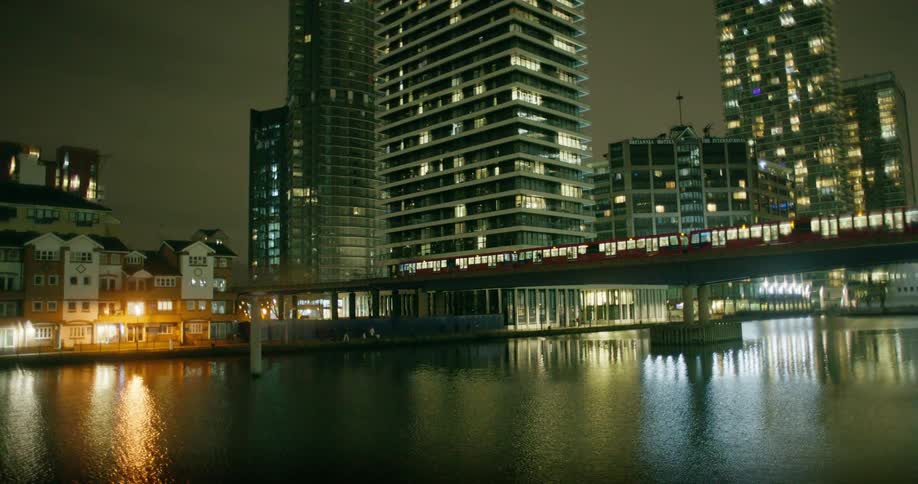 Wide shot of a train on a bridge passing over a river