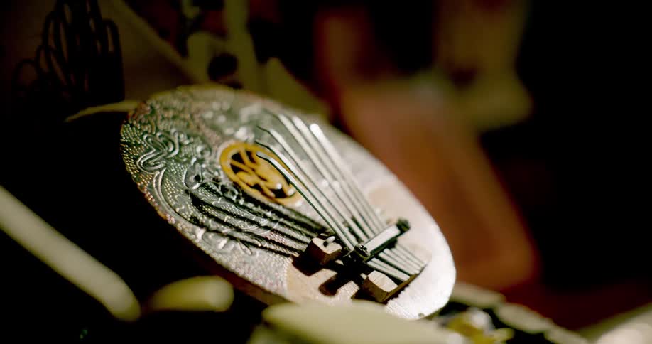 A shadow moves across an ornate circular musical instrument.