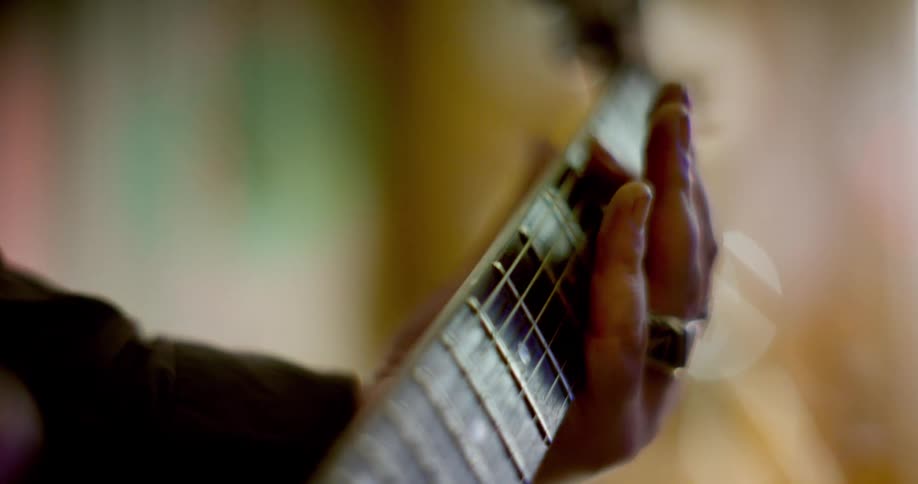 Close up of hands playing guitar