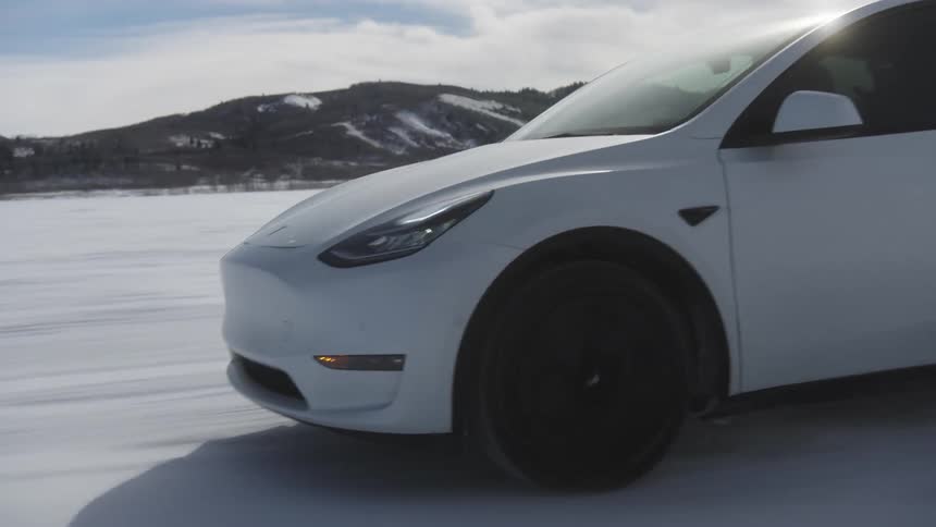 Tesla sports car traveling through snowcovered terrain in a natural environment