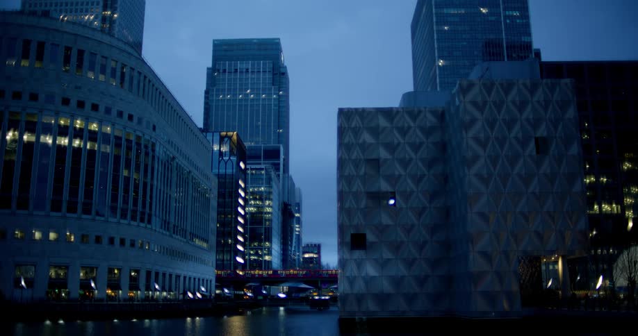 Footage of a city skyline a bus drives over a bridge in the distance