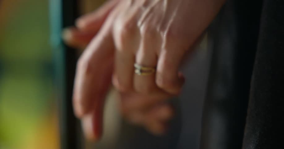 A woman squeezes her hands together