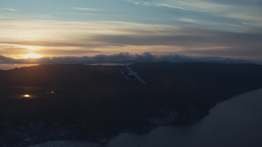 An airplane flies over a coastal area