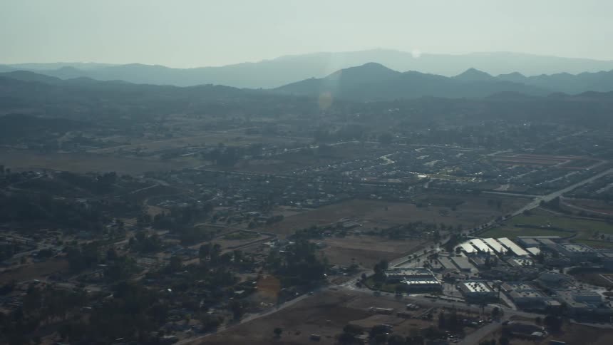 Aerial panorama of an urban city built on a plateau with mountains around it on a cloudless day