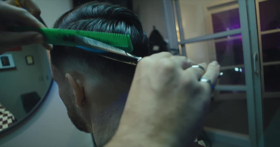 Point of view of a barbers hands giving a man a haircut