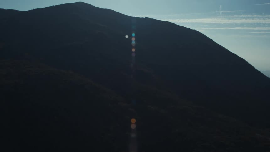 Aerial view of a mountain range silhouetted against a blue sky