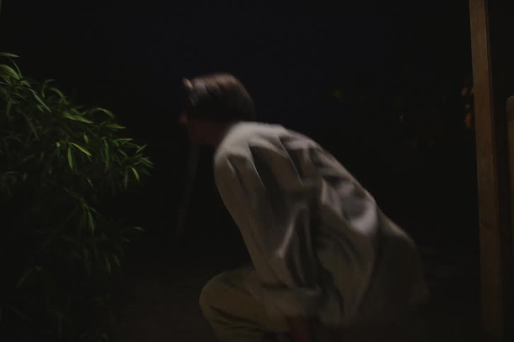 A man sitting on the floor gets up and walks away