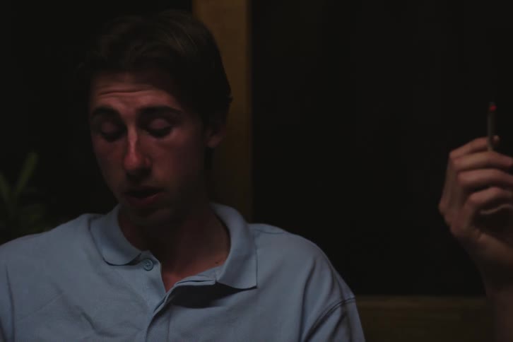 Portrait of two friends sitting and talking with one of them smoking