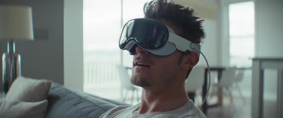 A man is sitting while wearing a virtual reality glasses on his face