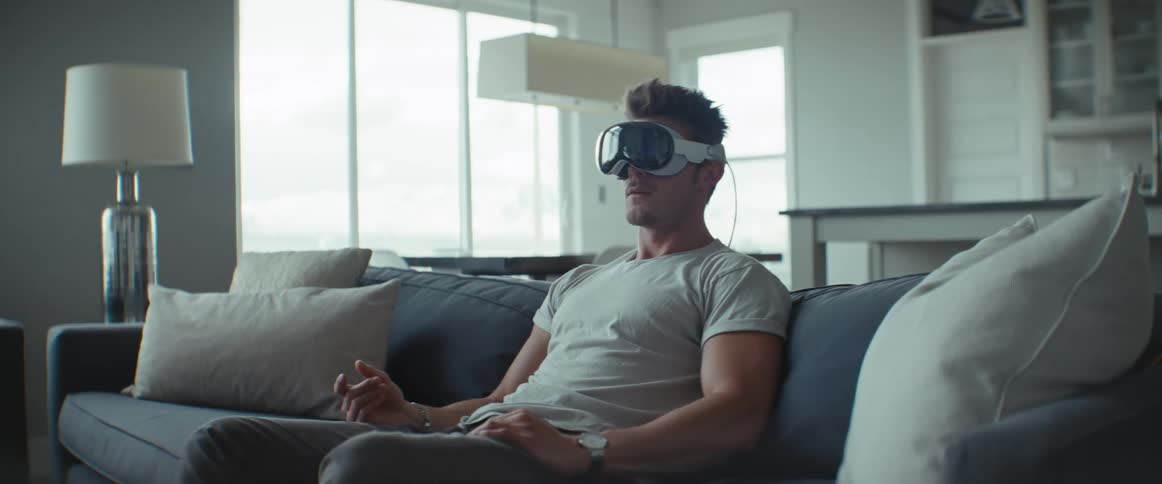 Man sitting on the couch while using virtual reality glasses