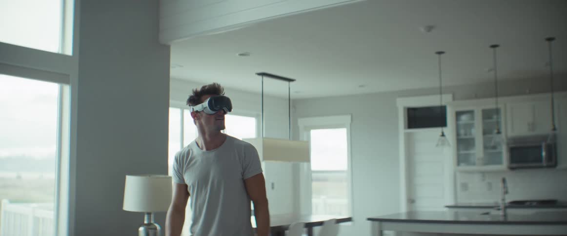 Man wearing a virtual reality headset smiles while walking back and forth in living room