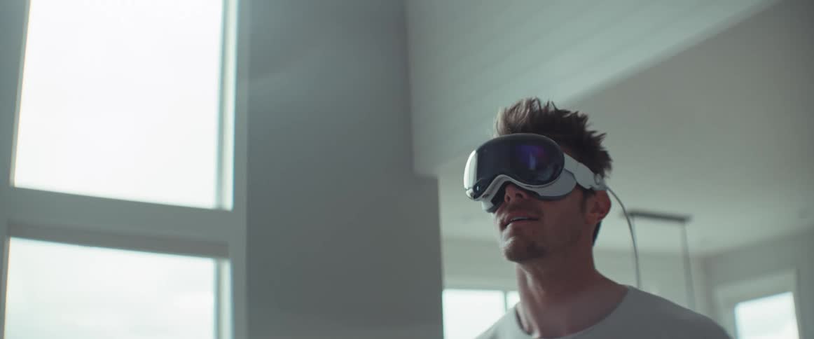 A man smiling while walking around a room wearing vr glasses
