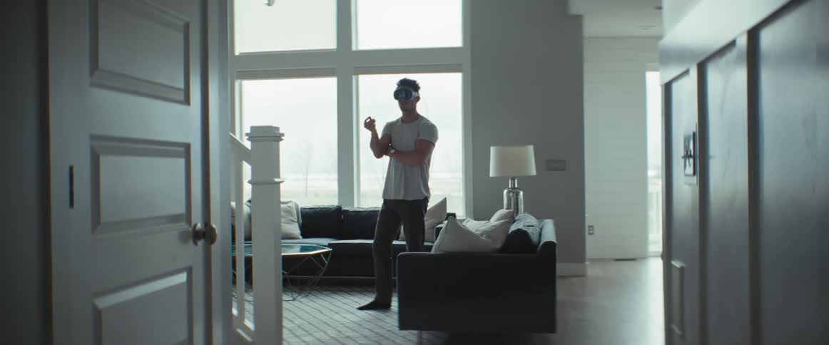 Man standing in living room using virtual reality glasses