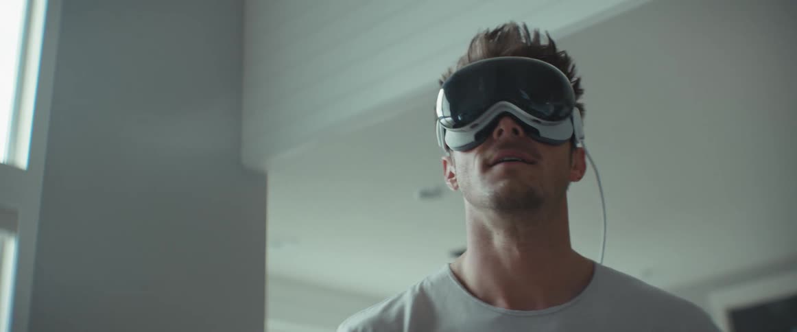 Standing man moving his arm while using virtual reality glasses