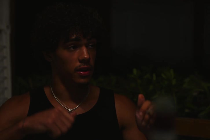 A man smokes a joint while talking to two other people