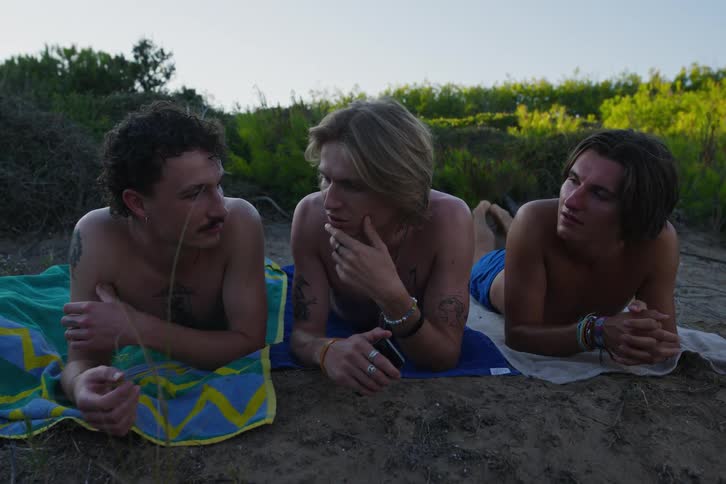 A group of guys out on the beach together playing games