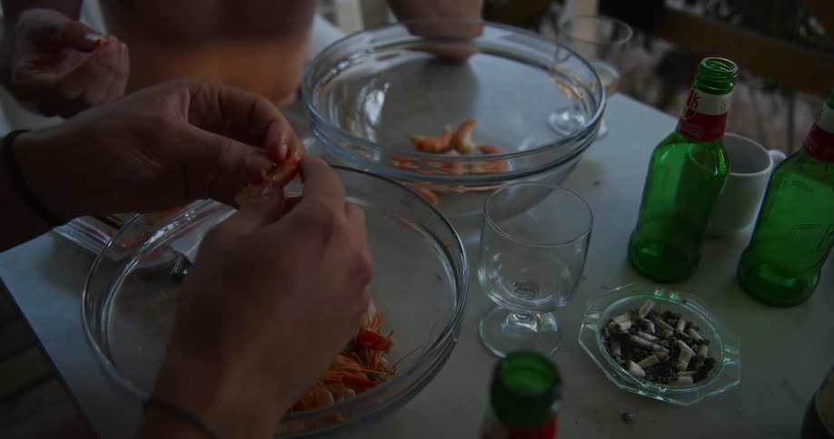 Two men prepare seafood for eating