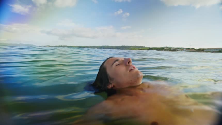 A guy swims and floats in the ocean