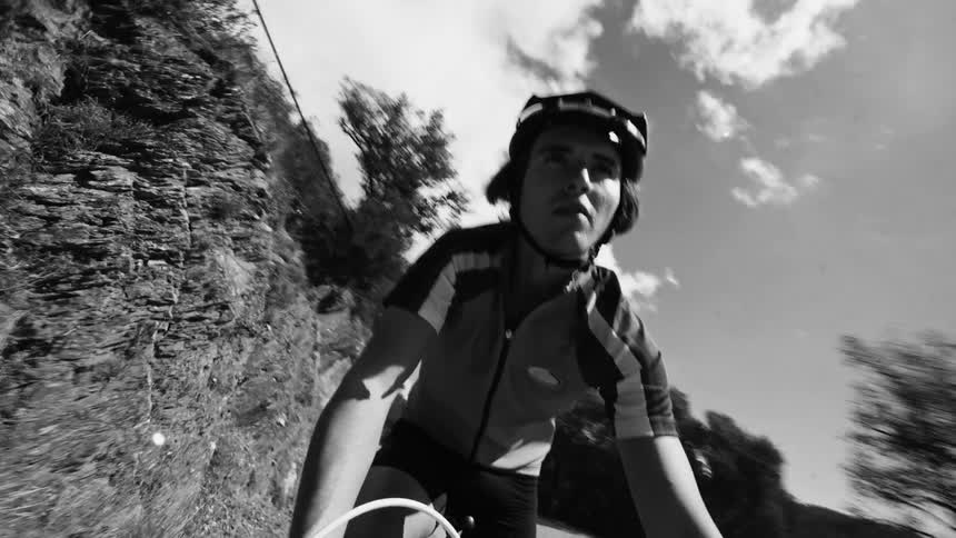 A teen rides a bicycle down a bumpy road