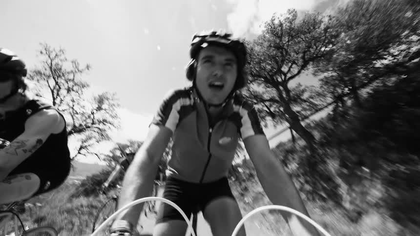 A group of friends ride bikes on a nature trail near a city