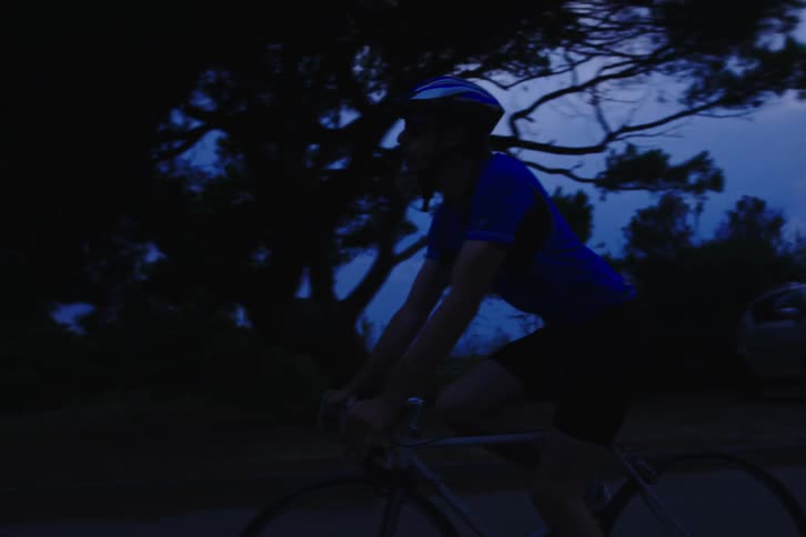 A man is riding his bicycle at sunset