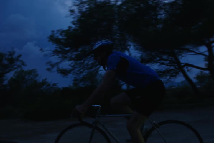 A group of people riding bicycles outdoors at night